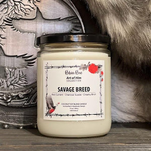 16 oz candle container with natural wax inside. Container label has a robin and a rose on it. Background has a viking shield and rabbit fur